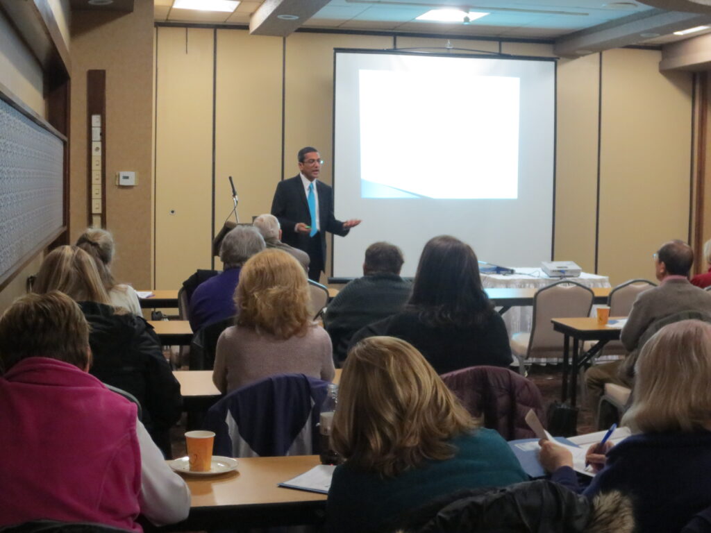 A man giving a presentation to an audience in a conference room.