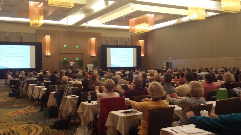 Audience attending a presentation in a conference room.
