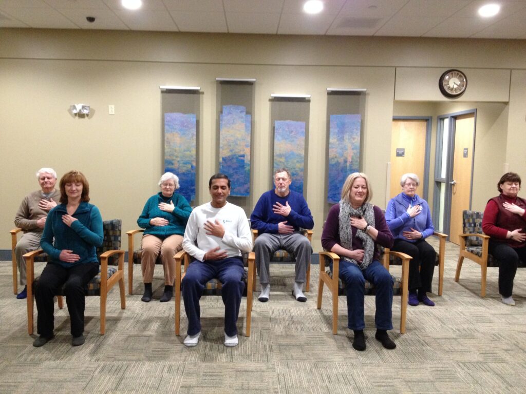 A group of elderly women sitting in chairs in a community room.