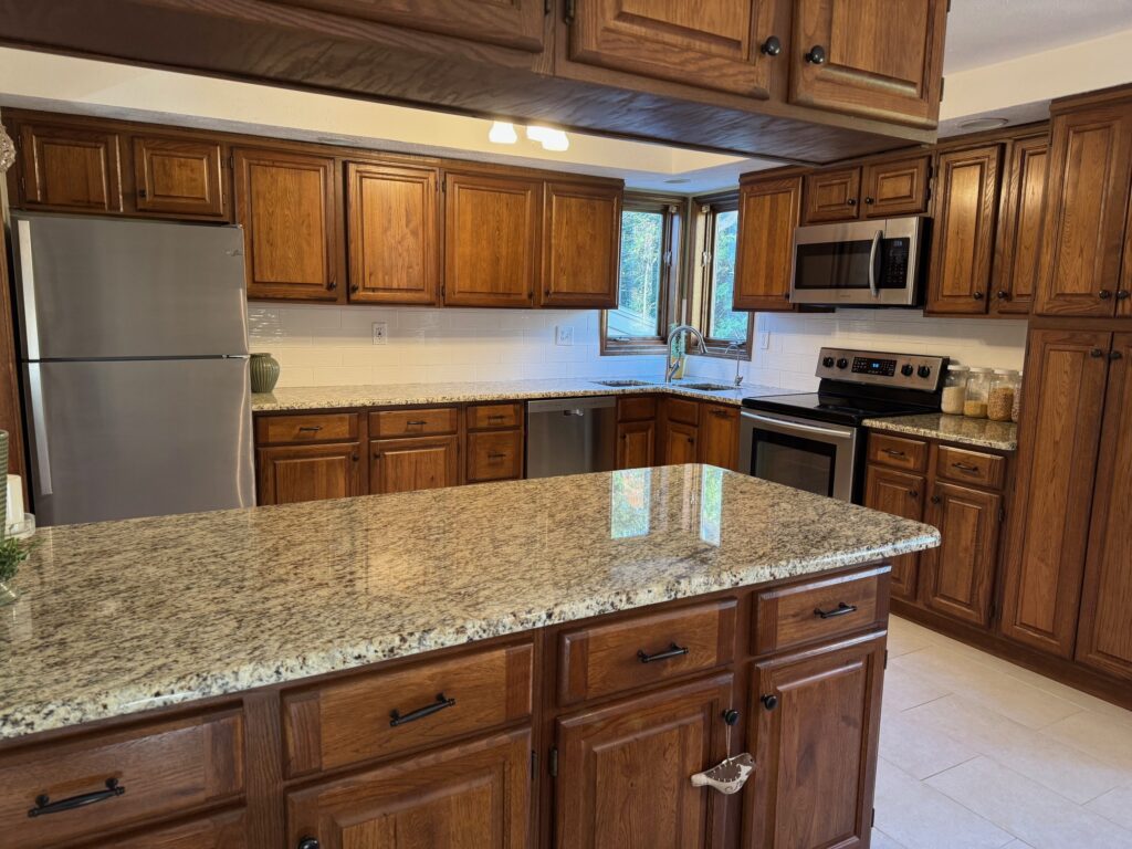 Modern kitchen with granite countertops and wooden cabinetry.